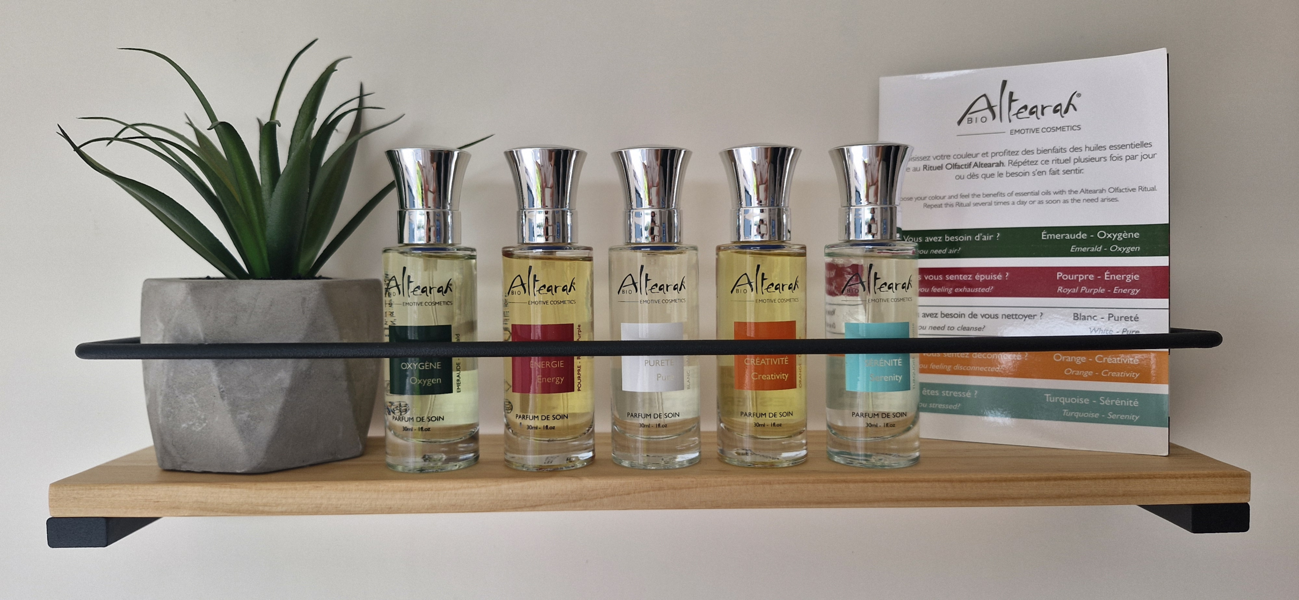 Les 5 parfums de soin Altearah sur une étagère, avec le livret des couleurs